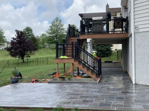 Decorative stamped concrete, composite deck, retaining wall, pavers, and planters were installed by Metric Concrete Construction & Design Inc
