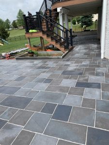 Custom stamped concrete patio with stained concrete,retaining wall, and deck installation